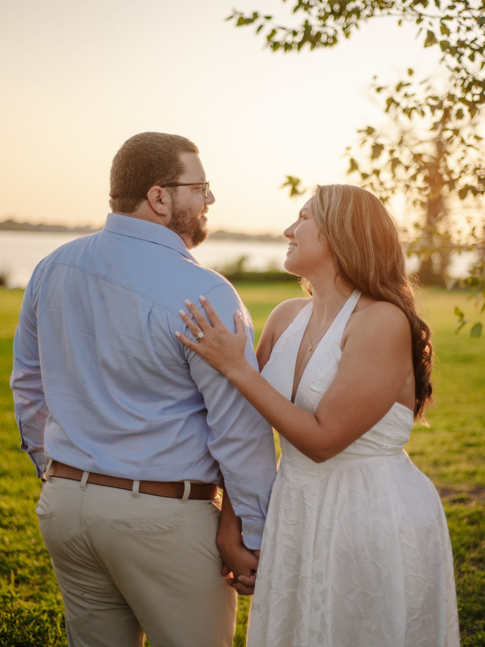 Katherine and Pierce turned toward each other on the lawn, the river and the setting sun behind them.
